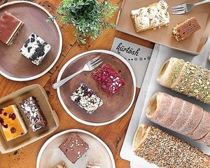 A selection of delicious pastries and cakes for sale, including vegan options. at Kürtősh in Randwick