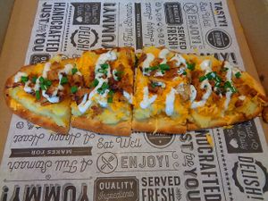 Mashed Potato Flatbread Special. House-made garlic smashed potatoes, shredded cheese, chives, tempeh bacon, chive aioli. Vegan. at Birch Cafe in Highland Heights