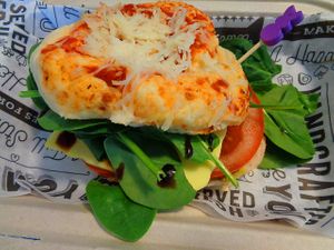 Sandwich Special Pizza Bagel Pesto Caprese, cold option. Locally made pizagel with walnut pesto, tomato slices, provolone cheese, wilted spinach, and a balsamic drizzle.  at Birch Cafe in Highland Heights