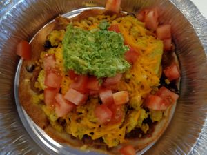 Les-bean Tostada from a Pride Month special. Fried flour tortilla topped with refried beans, tofu eggz, black beans, diced tomatoes, cheddar, mashed avocado. Vegan. at Birch Cafe in Highland Heights
