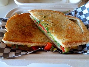Turk'y Pesto Grilled Cheese special. House-made seitan turk'y, provolone cheeze, roasted red peppers, house made spinach pesto, and arugula. Vegan. at Birch Cafe in Highland Heights