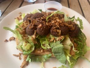 Falafel sandwich- note dark brown small falafels which were overly fried and rock hard  at La Bohème in Willemstad