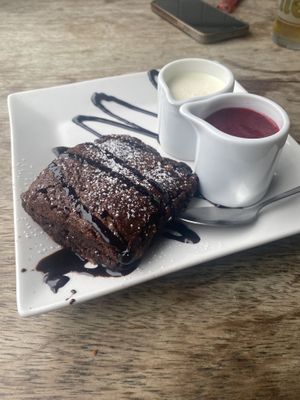 Hazelnut chocolate brownie with vegan cream and raspberry coulis   at Tywarnhayle Inn in Perranporth