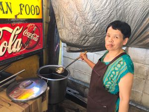 Friendly vegan woman serving soup at J La Thip in Lampang