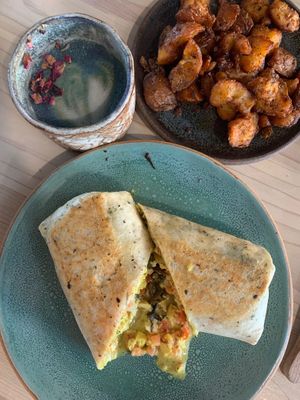 Breakfast burrito, butterfly matcha latte, crispy potatoes at Bearcat Cafe - CBD in New Orleans