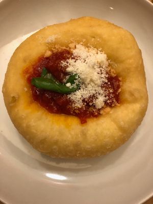 Deep fried pizza dough (traditional from Naples) with tomato sauce, parmigiano cheese and basil at la Cucina di Pastella in Rome