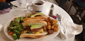 Breakfast sandwich with vegan sausage and potatoes. Coffee with oat milk. at Bonjour Cafe in Boston