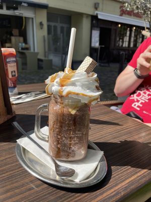 Vegan cosmopolitan milkshake—absolutely delicious and great hazelnut flavor!! Complete with caramel-drizzled whipped cream and a chocolate wafer cookie.  at Lenok's Burger - L15 in Mannheim
