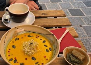 Pumpkin soup with crackers and nearly finished café au lait (almond milk) at Alge in Villach