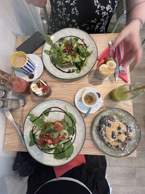 Espresso, green juice, açai and chai bowls, blueberry and peanut butter pancakes, I had the burrata toast without the burrata, my friend had a non vegan toast and a coffee.  at Healthy Lounge in Antibes