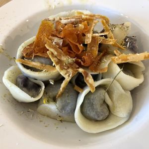 Purple carrot filled capelli with dehydrated chamomile, carrot crisps and lime oil   at Sfoglia Rina in Bologna