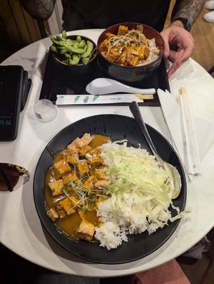 Tofu curry (nearest) and chilli tofu with edamame side at Pompoko in Brighton
