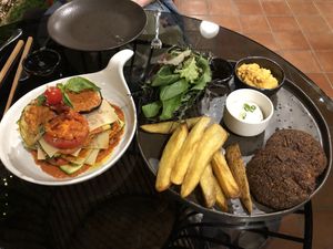 Lasagna (left, cooked version) and pesto kale steaks at Downtown - Vegan Garden Restaurant in Chiang Mai