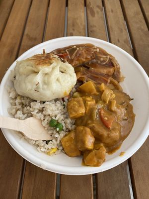 Fried rice with tofu curry and sweet and sour “fish”. Topped with a fried vegan bun at Root Vegetarian in Cairns