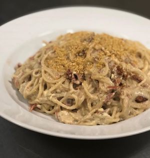“Spaghettini Carbonara” spaghettini in our creamy cashew Alfredo Sauce with vegan bacon , onion & tofu egg topped with cashew Parmesan cheese  at Paliottis Westside in Maple Ridge
