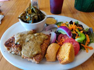 Pecan-crusted tofu atop mashed potatoes and gravy, served with side salad, collard greens and cornbread at Sluggo's North Vegetarian Cafe in Chattanooga
