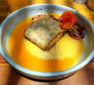 TOFU À BRASILEIRA
(R$ 46 em jan/22) Tofu marinado com crosta de castanhas e manteiga 
de ervas | Purê de banana da terra | Vinagrete de
feijão olho de cabra | Molho de moquec at Botanico - Colheita Criativa in Florianopolis