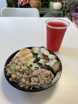 Seitan shawarma and rice underneath, with a dollop of walnut toona, hummus, chickpeas salad, olives, assorted veggies with a tzatziki drizzle. With on-tap passion fruit kombucha.  at Inika Foods in Wilton Manors