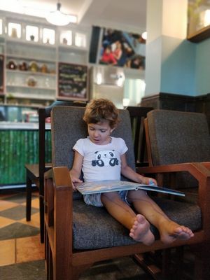 Young customer reading at Coffee Ideas in Auroville