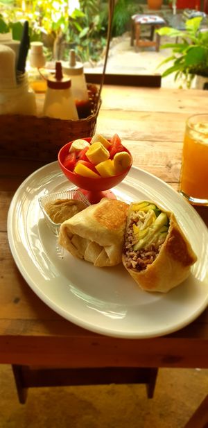 Vegan burrito with bell peppers, Pico de Gallo and corn, fresh fruit and Hummus. Glass of juice of the day. at Simon Says  in San Juan Del Sur