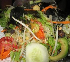 nori rolls atop salad with raw sesame dressing by brittany at Chef Brooke's Natural Cafe in Fort Myers