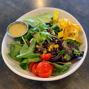 Sante Fe Salad - spring mix, corn and black bean relish, fresh cilantro, avocado and corn tortilla strips served with cilantro lime vinaigrette.  at The Panacea Restaurant in Wilmington