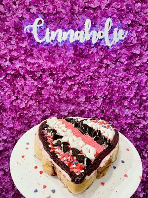 Cute flower wall next to our heart shaped cake!  at Cinnaholic in Schaumburg