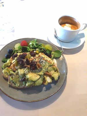 Avocado toast with berries, nuts and seeds. Coffee with soymilk (oat milk and almond milk also available) at But First Coffee in Saumur