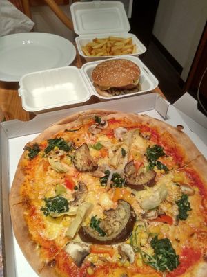 vegan pizza, burger and fries in the background at Urban Pizza in Vienna