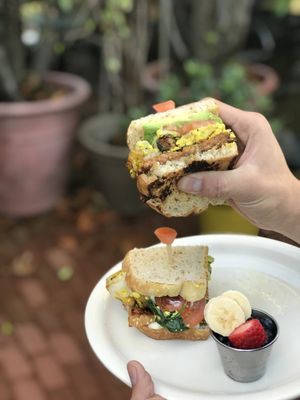 Sourdough breakfast sandwich stacked with scrambled tofu, maple glazed tempeh, avocado, roasted potatoes, tomato, spinach and vegan mayonnaise.   at Bliss Cafe in San Luis Obispo
