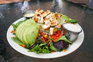 The avocado lemon love salad is topped with double the avocado, chickpeas, grilled tofu, carrots, sprouts and tomatoes, served with lemon love dressing and a side of cashew cheese! at Bliss Cafe in San Luis Obispo