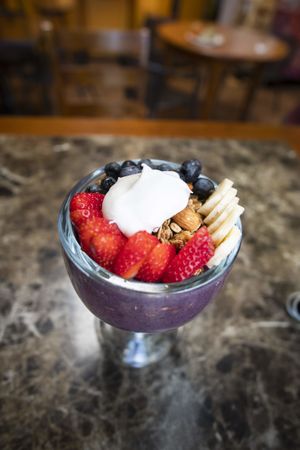 An açai blueberry chia smoothie bowl blended with fresh almond milk topped with house-made gluten free granola, bananas, berries and coconut whipped cream! at Bliss Cafe in San Luis Obispo