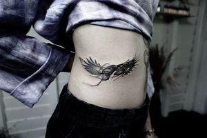 𝙄𝙂: 𝙣𝙖𝙩𝙚_𝙩𝙝𝙖𝙞𝙡𝙖𝙣𝙙 🌿 Ethereal blackwork raven tattoo on side waist - Baan Khagee Tattoo Chiang Mai, Thailand at Baan Khagee Tattoo in Chiang Mai