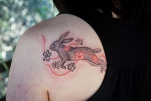 𝙄𝙂: 𝙣𝙖𝙩𝙚_𝙩𝙝𝙖𝙞𝙡𝙖𝙣𝙙 🍃 Rabbit tattoo with flowing desert rose flowers by a tattoo artist in Chiang Mai, Thailand at Baan Khagee Tattoo in Chiang Mai