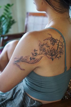 𝙄𝙂: 𝙣𝙖𝙩𝙚_𝙩𝙝𝙖𝙞𝙡𝙖𝙣𝙙 🍃 Flowing Asian Koi fish tattoo with flowers on the shoulder by a Thai tattooist in Chiang Mai at Baan Khagee Tattoo in Chiang Mai