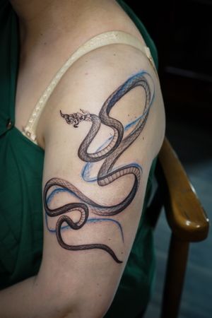 𝙄𝙂: 𝙣𝙖𝙩𝙚_𝙩𝙝𝙖𝙞𝙡𝙖𝙣𝙙 🍃 Fine line Thai Naga tattoo with flow on the shoulder by a Thai tattoo artist in Chiang Mai, Thailand at Baan Khagee Tattoo in Chiang Mai