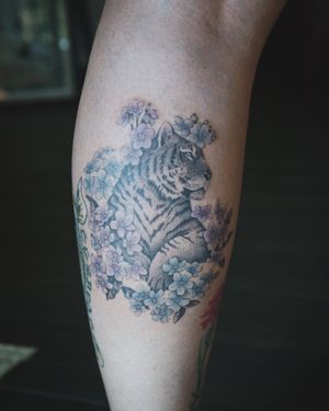 𝙄𝙂: 𝙣𝙖𝙩𝙚_𝙩𝙝𝙖𝙞𝙡𝙖𝙣𝙙 🍃 Fine line Tiger tattoo with Forget me not flowers by Baan Khagee Tattoo Chiang Mai, Thailand at Baan Khagee Tattoo in Chiang Mai