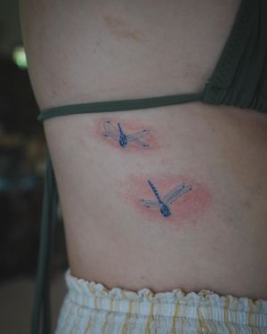 𝙄𝙂: 𝙣𝙖𝙩𝙚_𝙩𝙝𝙖𝙞𝙡𝙖𝙣𝙙 🍃 Flying dragonflies tattoo on the side ribcage by Baan Khagee Tattoo Chiang Mai, Thailand at Baan Khagee Tattoo in Chiang Mai