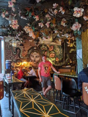 Murals on the walls and magnolia tree above at Rampart Treehouse in New Orleans