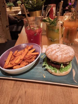 Pfefferbusch burger, sweet potato fries, large passionfruit drink, Goldfink alcohol-free cocktail at Hans im Glück in Starnberg