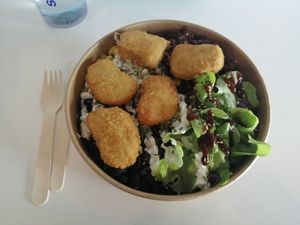 Large rice bowl (bigger than it looks) with lettuce, soya pieces, corn, black beans, basil mayo, alhamada BBQ and vegan nuggets at Brote de Primavera in Chillan
