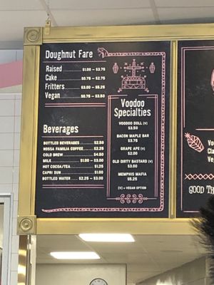 Price menu. In store hand held menus have the pictures and descriptions of donuts. There are also rotating glass cabinets showcasing doughnuts.  at Voodoo Doughnut - Washington Ave in Houston