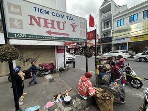 The sign the seller is next to.  at Banh Mi Chay Co Hoa in Da Lat