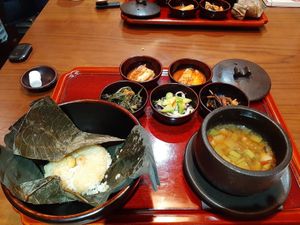 4th, main: rice in lotus leaf and fermented bean soup. the side dishes including kimchi are vegan at Balwoo Gongyang - 발우공양 in Seoul