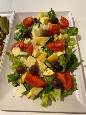 Seasonal salad with lettuce, tomatoes, black olives and apples  at MadoniEAT in Palermo