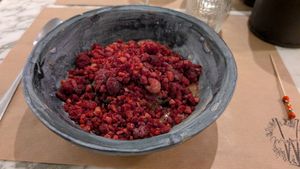 Raw brownie topped with frozen raspberries at Winners Vegan Restaurant in Athens