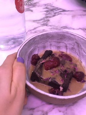 Sweet potato brownie with dates and tahini, served with berries and peanut butter caramel sauce. at Winners Vegan Restaurant in Athens