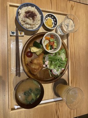 Brown rice set with 2 salad and fried chickpea samosas,fried zucchini, mushroom miso soup, pickles and apple juice.   at Seren Table in Takatsuki