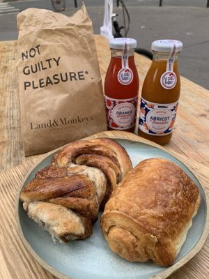 Braided cinnamon roll and traditional ‘pain au chocolat’ completed with organic juices.  at Land & Monkeys - Beaumarchais in Paris