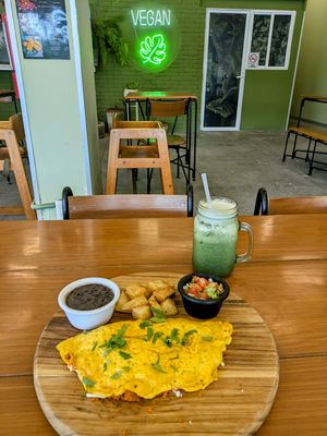 "Omelette" from chickpea flour stuffed with vegan chorizo and vegan cheese, frijoles, salsa and roasted potatoes & green juice at Herbivoro in Cancun